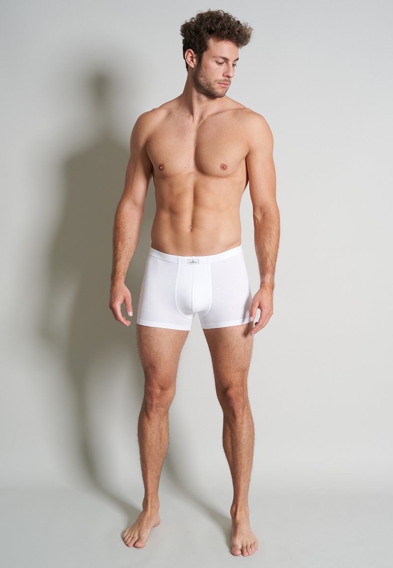 Weiße Baumwoll-Boxershorts mit engem Sitz und elastischem Bund. Glatte Textur, kurzer Beinschnitt, keine sichtbaren Muster oder Akzente.