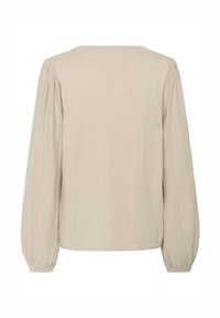 Lys beige langærmet top med lige snit, rund halsudskæring og teksturerede lodrette sømme langs ærmerne. Blødt strikstof.