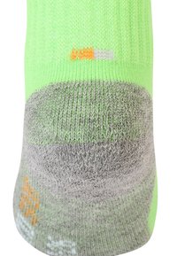 Neon-grüne Socke mit einem grauen, strukturierten Fußbett. Verfügt über orangefarbene und weiße Nähte. Strickstoff mit einer engen Passform.