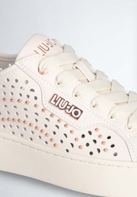 Sneaker beige Liu Jo con pelle perforata, dettagli in rosa oro, lacci piatti e suola platform con piccoli borchie e logo.