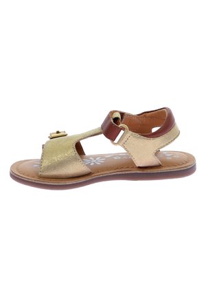 Sandalia de cuero dorado con punta y talón descubiertos, tira marrón con cierre de hebilla, suela plana, plantilla con estampado floral y texturas contrastantes.