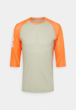 Lysegrå kortærmet skjorte med lyseorange raglanærmer og krave, med en diskret hvid logo på venstre ærme.