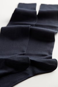 Schwarze Baumwollsocken mit einer glatten Textur, geripptem Bündchen und einem klassischen Design. Gefaltet mit einem sauberen Finish und ohne sichtbare Muster.