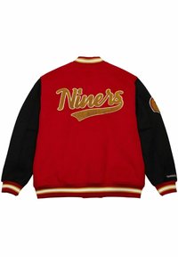 Rot und schwarze Collegejacke mit dem Text "Niners" in goldener Stickerei auf dem Rücken; gerippter Kragen und Bündchen mit gelben und roten Streifen.