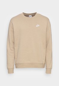 Sudadera beige hecha de una mezcla de algodón, con cuello redondo, mangas largas, puños acanalados y un logotipo blanco de Nike en la parte superior izquierda del pecho.