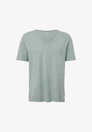 Miętowa koszulka z krótkim rękawem i dekoltem w serek, uszyta z miękkiego materiału, o luźnym kroju z małą metką marki na dolnym brzegu.