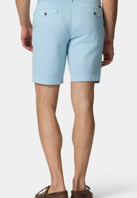 Světle modré bavlněné šortky s ohrnutým lemem, zadní kapsy s knoflíkovým zapínáním a rovný střih. Hladká textura a jednoduchý design.