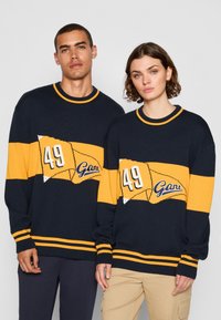 Sweter dzianinowy w granatowym i żółtym kolorze, z dużą grafiką przedstawiającą "49" i "Gar" z przodu. Posiada okrągły, prążkowany dekolt oraz mankiety.