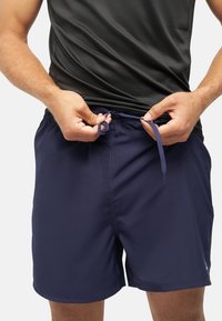 Costumi da bagno blu navy con vita elastica e cordino regolabile. Tessuto morbido, lunghezza a metà coscia, con tasche laterali.