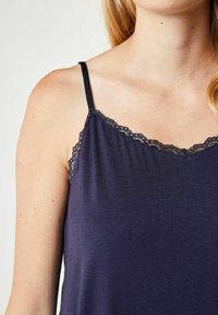 Mørkeblå tank top lavet af blødt stof, med tynde stropper og delikat blonderkant langs halsudskæringen, glat tekstur og afslappet pasform.