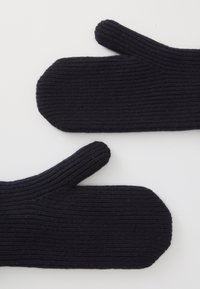 Manoplas de punto en un oscuro tono azul marino con textura acanalada y sección de pulgar separada. Forma suave y redondeada, sin hardware o acentos visibles.