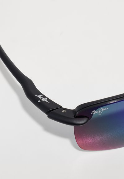 Lunettes de soleil noires au design élégant, lentilles dégradées violettes et accents brillants. Présente un logo sur la branche et une texture lisse.