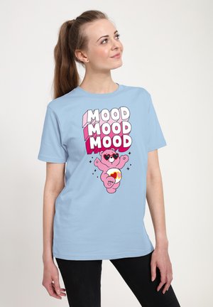Lysblå t-shirt med et pink bjørne-motiv iført hjerteformede solbriller og teksten "MOOD" i fed, farverig skrifttype. Blødt bomuldsstof.