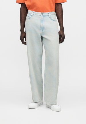 Jeans a gamba larga color azzurro chiaro in denim, con vita alta, design a cinque tasche e leggero scolorimento. Abbinati a sneaker bianche.