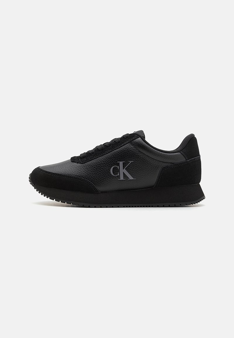 Baskets basses noires en cuir texturé, accents en suède, fermeture à lacets et logo "cK" sur le côté.