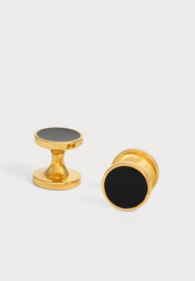 Paire de boutons de manchette dorés avec faces rondes en émail noir sur fond blanc.
