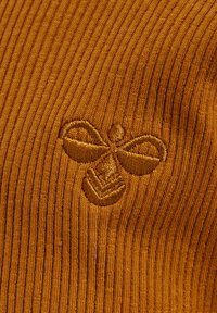 Senfgelbes, geripptes Strickgewebe mit einem strukturierten, gestickten Bienendesign, das die Weichheit des Materials und die feinen Details betont.