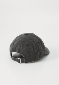 Șapcă de baseball din bumbac negru, cu vizor curbat, curea ajustabilă la spate și suprafață texturată. Include orificii de ventilație.