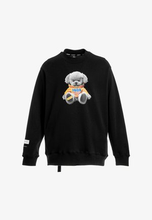 Sudadera negra con un gráfico frontal de un oso de peluche gris que lleva una sudadera con capucha naranja con texto azul, mostrado sobre un fondo blanco.