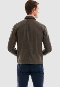 Brun læderjakke med quilted krave og skulderdetaljer, der har en glat overflade og en tætsiddende pasform.