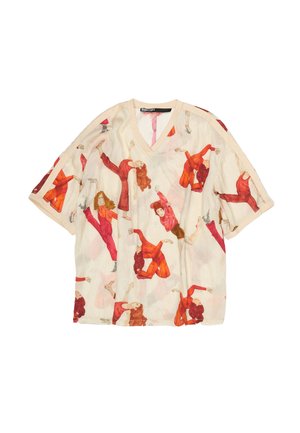 Šviesiai rudas V formos kaklo trumpomis rankovėmis marškinėlis su viso paviršiaus raštu, vaizduojančiu moteris įvairiais raudonos ir oranžinės spalvų drabužiais, užimiančias dinamiškas šokio pozas.