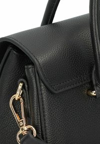 Borsa a mano in pelle nera con finitura testurizzata, hardware dorato, manico superiore e dettaglio di chiusura a aletta. Le caratteristiche di design principali includono un attacco a clip.