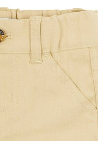Pantaloni in cotone beige con vita piatta, passanti per la cintura e tasche frontali. Presentano una struttura liscia e dettagli di cuciture a contrasto.