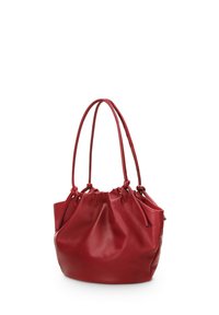 Red leather bucket bag with drawstring closure, featuring two handles and a smooth, glossy texture. Round base design enhances shape.