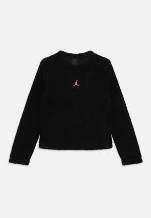 Haut en polaire noir à manches longues avec col rond et logo Jumpman doré centré sur la poitrine, présenté à plat sur un fond blanc.