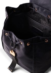 Borsa in tessuto nero con superficie testurizzata, dettagli in hardware dorato, chiusura con cordoncino e tasca interna con etichetta.