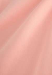 Tissu rose doux et lisse avec des plis délicats et une finition mate, mettant en valeur sa texture et son tombé.