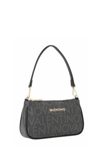 Sac à main en cuir noir avec un motif répétitif du logo "Valentino", une bandoulière courbée, des accessoires dorés et une fermeture éclair.