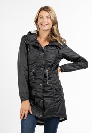 Giacca leggera nera con cappuccio, caratterizzata da chiusura con bottoni, vita regolabile con cordino, polsini elastici e due tasche frontali. Tessuto liscio e lucido.