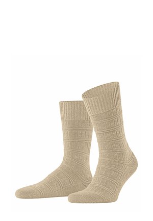 Beige knitted socks with a ribbed texture and horizontal pattern. Ankle-length design with a reinforced toe area for durability.