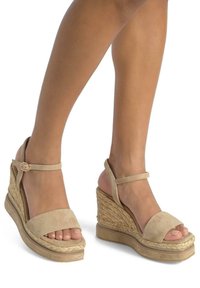Beige Keilsandaletten aus Wildleder mit einer gewebten Jute-Plattform. Verfügt über einen Knöchelriemen mit Schnalle und ein offenes Zehendesign. Strukturiertes Finish.