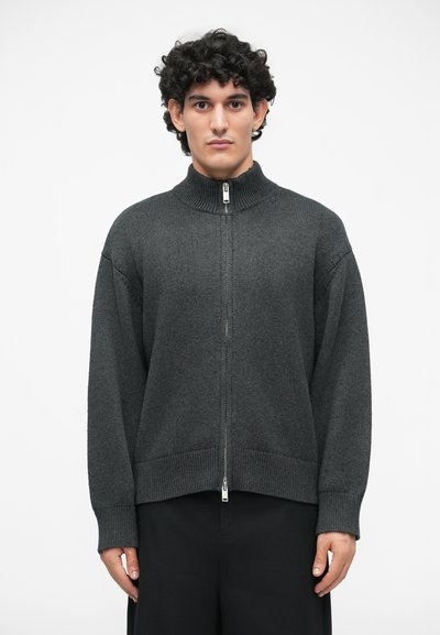 Tmavošedý sveter na zips, so rebrovaným golierom a manžetami, vo voľnom strihu, vyrobený z jemnej úpletu, s diskrétnym zipsom vpredu.