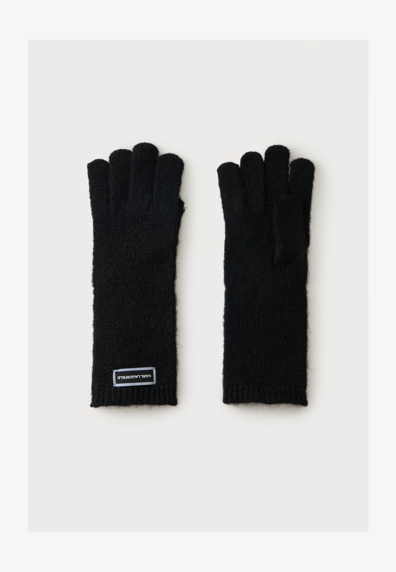Paire de gants en laine noire tricotés à cinq doigts, un gant avec une petite étiquette rectangulaire près du poignet.