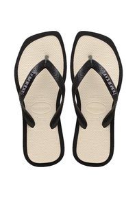 Svart gummiflip-flops med teksturerte stropper, solid såle, og beige fotbed med preget logo og størrelsesdetaljer.
