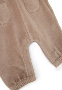 Braune Corduroy-Overalls mit zwei vorderen Taschen, elastischen Bündchen und einer weichen Textur. Verfügt über einen abgerundeten Beinausschnitt für mehr Bewegungsfreiheit.