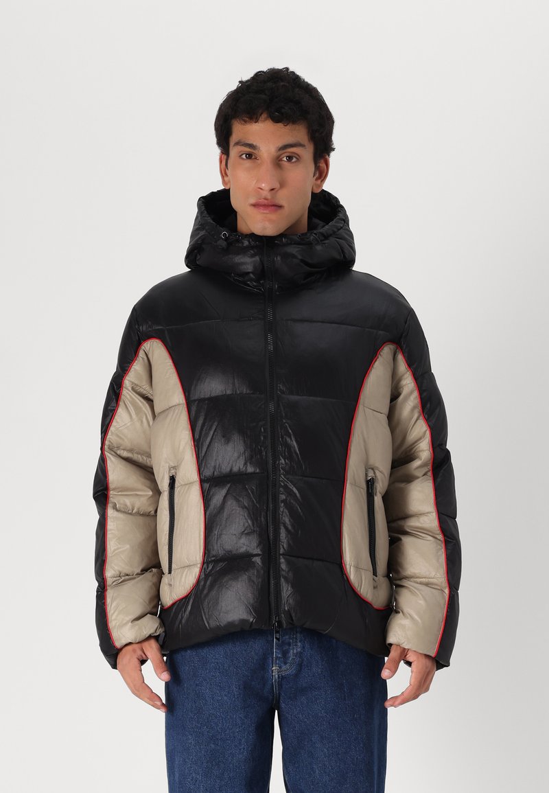 Casaco bomber com um corpo preto brilhante, painéis bege e detalhes vermelhos. Tem capuz, fecho na frente e dois bolsos laterais.