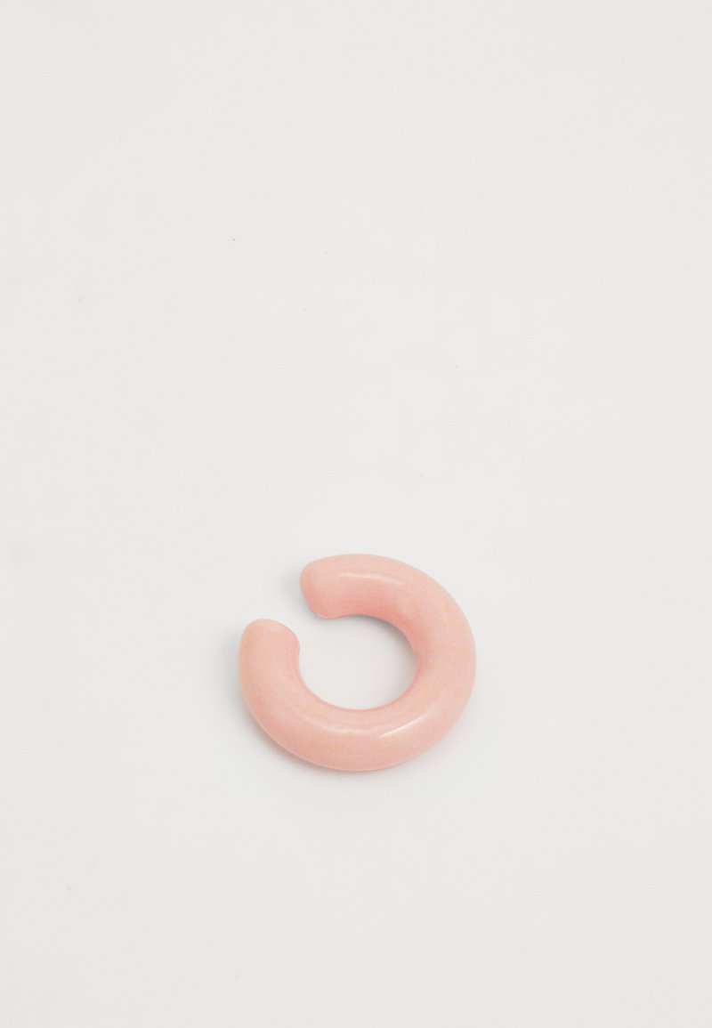 Circular hair accessory made of glossy, light pink resin, featuring a smooth texture and open center, resembling a crescent shape.