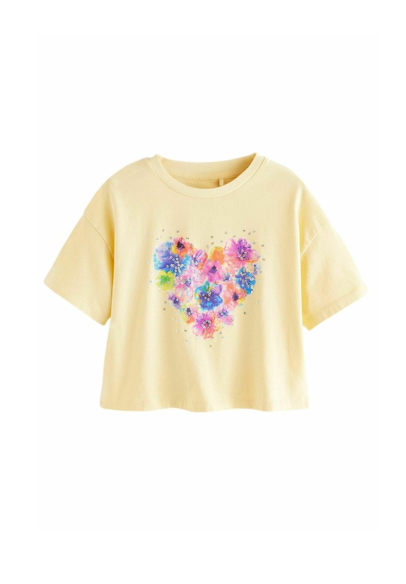 Gelbes, kurzes T-Shirt mit kurzen Ärmeln, das ein farbenfrohes florales Herzdesign zeigt, verziert mit kleinen Glitzerpartikeln. Aus weichem Baumwollmaterial.