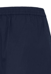 Shorts à taille élastique bleu marine en tissu léger, montrant la partie supérieure et le détail de la taille froncée.