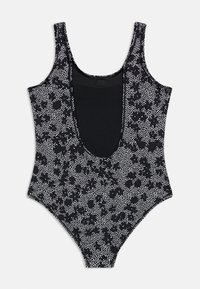 Μαύρο ολόσωμο μαγιό με λευκό πουά ανθικό σχέδιο και βαθύ ντεκολτέ, φωτογραφημένο σε απλό φόντο.