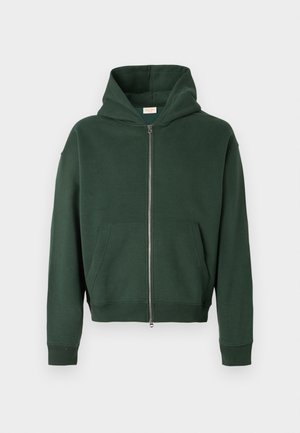 Grøn zip-up hoodie i blød bomuldsblanding, med en stor hætte, kengurulommer og ribbede manchetter og kant. Minimalistisk design.