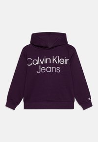 Felpa con cappuccio viola realizzata in tessuto morbido, con un grande logo frontale che recita "Calvin Klein Jeans" in bianco e grigio a contrasto.
