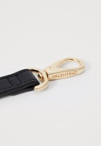 Cinturino in pelle nera con chiusura in metallo dorato, caratterizzato da un piccolo logo, superficie texturizzata e finitura lucida. Ideale per accessori.