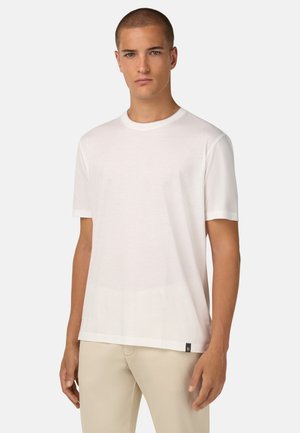 T-shirt bianco a girocollo realizzato in tessuto morbido, con maniche corte e taglio dritto. Presenta un piccolo etichetta nera all'orlo.