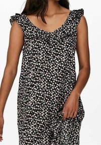 Černé květinové šaty s véčkovým výstřihem, volánkovými rukávy a drobnými růžovými a bílými květy na průsvitné látce, které vytvářejí lehkou, tekoucí siluetu.