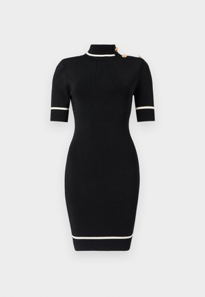 Μαύρο εφαρμοστό φόρεμα μέχρι τα γόνατα με κοντά μανίκια, λευκή επένδυση στο γιακά, τα μανίκια και το τελείωμα, και χρυσά κουμπιά στον αριστερό ώμο.